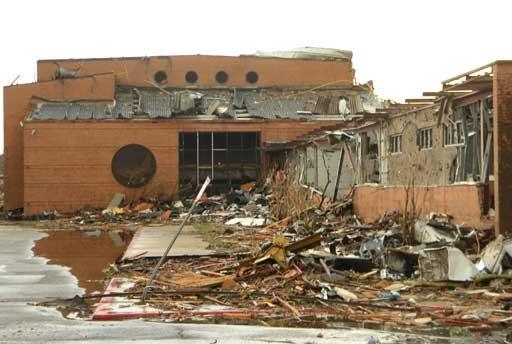 Building severely damaged by the tornado, extensive wall damage.